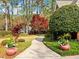 A concrete walkway leads to a beautiful home, framed by lush landscaping and vibrant trees at 1544 Blue Bird Way, Cumming, GA 30041