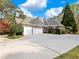 A large concrete driveway leads to a spacious two-car garage attached to a charming brick home at 1544 Blue Bird Way, Cumming, GA 30041