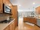 Well-lit kitchen featuring granite countertops, stainless steel appliances, and wooden cabinetry at 1544 Blue Bird Way, Cumming, GA 30041