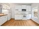 Well-lit kitchen showcasing white cabinetry, modern appliances, and wood flooring at 1544 Blue Bird Way, Cumming, GA 30041
