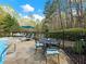 Outdoor stone patio featuring a dining table with a pool in the background at 1544 Blue Bird Way, Cumming, GA 30041