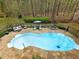 Aerial view of the in-ground pool, stone patio, and lounge seating in the private backyard at 1544 Blue Bird Way, Cumming, GA 30041