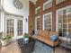 A cozy screened-in porch featuring comfortable seating, decorative pillows, and views of the backyard at 1544 Blue Bird Way, Cumming, GA 30041