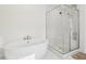 Bright bathroom featuring a soaking tub, glass shower and white marble tile at 278 Tillman Pass, Woodstock, GA 30188
