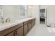 Bright bathroom featuring double sink vanity, white marble floors and brown cabinets at 278 Tillman Pass, Woodstock, GA 30188