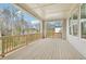 Covered deck offers outdoor living space with wood flooring, railing, and neighborhood views at 278 Tillman Pass, Woodstock, GA 30188