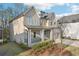 Two-story home featuring a covered front porch, a front-facing garage, and lush landscaping at 278 Tillman Pass, Woodstock, GA 30188