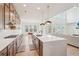 Open kitchen with island, modern appliances, wood floors, and seamless flow into the dining and living areas at 278 Tillman Pass, Woodstock, GA 30188