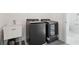 Modern laundry room with sleek black washer and dryer next to sink and window at 278 Tillman Pass, Woodstock, GA 30188