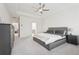 A Primary bedroom with a bed, carpet, fan, tray ceiling, and ensuite bathroom at 278 Tillman Pass, Woodstock, GA 30188
