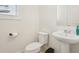 Cozy powder room with pedestal sink, toilet, and natural light from window at 278 Tillman Pass, Woodstock, GA 30188