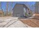 View of the side exterior showcasing a two-car garage and landscaped yard with lush greenery at 4843 Caboose Nw Ln, Acworth, GA 30102