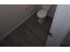Standard toilet in bathroom with gray wood-look flooring, providing a practical and modern aesthetic at 7267 Appaloosa Cv, Fairburn, GA 30213