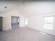 Spacious room with neutral carpet, vaulted ceiling, and multiple windows for ample natural light at 7267 Appaloosa Cv, Fairburn, GA 30213