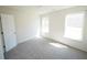Bright bedroom with neutral carpet, white walls, and natural light from two windows at 7267 Appaloosa Cv, Fairburn, GA 30213