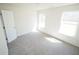 Bright bedroom features neutral walls, soft carpet, and natural light from two windows at 7267 Appaloosa Cv, Fairburn, GA 30213