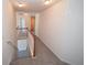 Upstairs hallway features neutral carpet and railing leading to multiple rooms at 7267 Appaloosa Cv, Fairburn, GA 30213