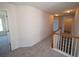Upstairs hallway boasts neutral carpet, white walls, and views to multiple rooms at 7267 Appaloosa Cv, Fairburn, GA 30213
