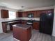 Modern kitchen featuring dark wood cabinetry, stainless steel appliances, and center island at 7267 Appaloosa Cv, Fairburn, GA 30213