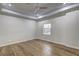 Bright bedroom with hardwood floors, a tray ceiling, and a window overlooking the yard at 810 Commodore Nw Dr, Atlanta, GA 30318