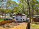 The backyard with new fencing and freshly installed exterior paint is surrounded by tall, mature trees at 1350 Elizabeth Sw Ave, Atlanta, GA 30310