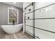 The bright bathroom features a glass-enclosed shower, modern vanity and a soaking tub near a bright window at 1350 Elizabeth Sw Ave, Atlanta, GA 30310