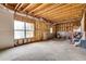 Unfinished basement space with exposed beams and a large window, offering potential for customization at 179 Bradshaw Park Dr, Woodstock, GA 30188