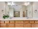 Bright bathroom with double sink vanity with wood cabinets, a large mirror, and a decorative plant at 179 Bradshaw Park Dr, Woodstock, GA 30188