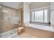 Bright bathroom featuring a shower with glass door and a bathtub with a decorative window at 179 Bradshaw Park Dr, Woodstock, GA 30188