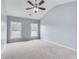 Spacious bedroom with vaulted ceilings, neutral carpet, two windows, and a ceiling fan with light fixture at 179 Bradshaw Park Dr, Woodstock, GA 30188
