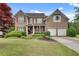 Charming two-story brick home featuring a well-manicured lawn and a two-car garage at 179 Bradshaw Park Dr, Woodstock, GA 30188