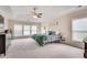 Bright main bedroom featuring large windows, a ceiling fan, and neutral carpet at 179 Bradshaw Park Dr, Woodstock, GA 30188