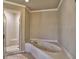 Bright bathroom featuring a white jacuzzi tub and glass enclosed shower at 3012 Asheton Ne Pl, Marietta, GA 30068