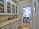 Butler's pantry with display cabinets and adjacent to a kitchen with a center island at 3012 Asheton Ne Pl, Marietta, GA 30068