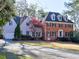A beautiful two-story home features a brick facade, dark shutters, and a well-manicured front lawn at 3012 Asheton Ne Pl, Marietta, GA 30068