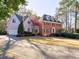 Charming two-story home with a well manicured lawn and mature trees on a sunny day at 3012 Asheton Ne Pl, Marietta, GA 30068