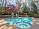 Backyard pool features a slide, spa, and surrounding mature trees creating a private oasis at 3012 Asheton Ne Pl, Marietta, GA 30068