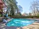 Backyard pool features a slide, spa, and surrounding mature trees creating a private oasis at 3012 Asheton Ne Pl, Marietta, GA 30068