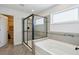 Bright bathroom featuring a tub and a glass-enclosed shower with tile surround and a closet at 3774 Thackary Dr, Powder Springs, GA 30127