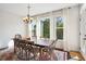 Sun-filled dining room featuring a wooden table, seating for six, and large windows with sheer curtains at 3774 Thackary Dr, Powder Springs, GA 30127