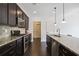Modern kitchen featuring stainless steel appliances, dark wood cabinets and a large island at 3774 Thackary Dr, Powder Springs, GA 30127