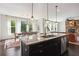 Open concept kitchen with granite island, stainless appliances, and adjacent dining and living areas at 3774 Thackary Dr, Powder Springs, GA 30127
