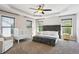 Bright main bedroom featuring a ceiling fan, a walk-in closet, and a comfortable seating area at 3774 Thackary Dr, Powder Springs, GA 30127