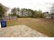 Large backyard featuring a stone patio area, wood fence perimeter, and lush greenery in the background at 102 Silver Fox Trl, Dallas, GA 30157