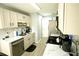 Galley kitchen features white cabinets, stainless appliances, and marble countertops at 102 Silver Fox Trl, Dallas, GA 30157