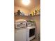 Functional laundry room with washer, dryer, and overhead shelving for storage at 102 Silver Fox Trl, Dallas, GA 30157