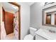 Bright bathroom featuring a marble countertop, wood door, and white tile flooring at 4258 Rocky Ledge Way, Snellville, GA 30039