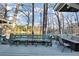 A lovely outdoor deck space is set with a dining table and chairs and has a bench overlooking the lake at 4258 Rocky Ledge Way, Snellville, GA 30039