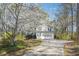 Charming two-story home with a long driveway, set against a backdrop of lush greenery and flowering trees at 656 New Hope Rd, Lawrenceville, GA 30046