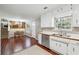 Bright kitchen featuring white cabinetry, stainless steel appliances, and an adjacent dining area with wood floors at 656 New Hope Rd, Lawrenceville, GA 30046